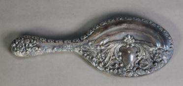 EDWARD VII EMBOSSED SILVER CLAD HAND MIRROR with oval, bevel edged plate, decorated with flower head