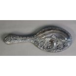 EDWARD VII EMBOSSED SILVER CLAD HAND MIRROR with oval, bevel edged plate, decorated with flower head