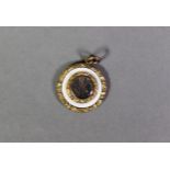 VICTORIAN ROLLED GOLD SMALL CIRCULAR DISC PENDANT the centre with a glazed plaited hair locket, with