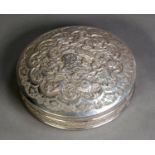 MIDDLE EASTERN EMBOSSED SILVER COLOURED METAL CIRCULAR BOX AND COVER, of shallow form with domed