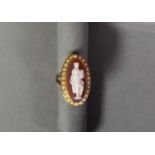 ANTIQUE GOLD RING with four strand wire pattern shank, the narrow oval top collet set with a cameo