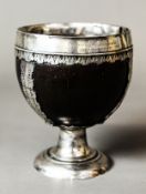 AN 18TH CENTURY SILVER MOUNTED COCONUT CHALICE, probably used for holy communion, inscribed for {