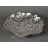 PIERCED SILVER SHALLOW DISH, of lobated form with floral pierced panels and ball feet, 2 ½” (6.