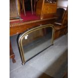 A VICTORIAN ARCH TOPPED OVER MANTEL MIRROR, IN EBONISED GILT FRAME