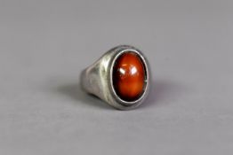 SILVER COLOURED METAL RING (no marks remaining), collet set with a cabochon oval brown agate, ring