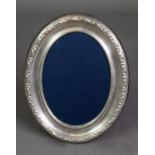 MODERN EMBOSSED SILVER FRONTED DESK TOP PHOTOGRAPH FRAME, of oval form with blue plush lined back