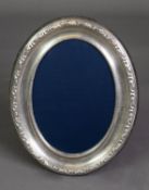 MODERN EMBOSSED SILVER FRONTED DESK TOP PHOTOGRAPH FRAME, of oval form with blue plush lined back