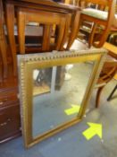 A GILT FRAMED CARVED WALL MIRROR