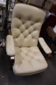 A MID CENTURY STYLISH OPEN ARMCHAIR, COVERED IN CREAM LEATHER WITH BUTTON BACK AND SEAT WITH STAINED