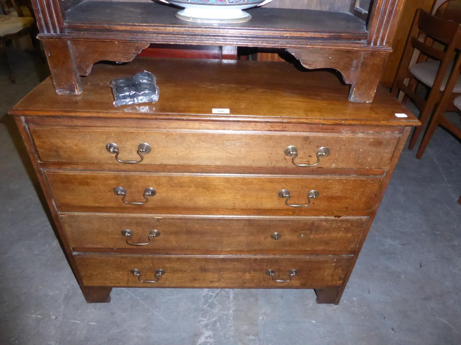 AN OAK CHEST OF DRAWERS, HAVING FOUR GRADUATED DRAWERS