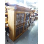 A PITCH PINE BOOKCASE, ELEVATED SECTION, HAVING TWO GLAZED DOORS