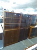 A PAIR OF SAPELE MAHOGANY BOOKCASES, EACH WITH GLASS SLIDING DOORS ABOVE A CUPBOARD BASE, 2’3” WIDE,