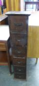 A VINTAGE HARDWOOD TALL, NARROW NEST OF SIX CARD INDEX DRAWERS, WITH BRASS FRAME HANDLES, 9’ WIDE,