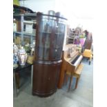 A DARK MAHOGANY BOW FRONTED DOUBLE CORNER CUPBOARD WITH SHAPED PEDIMENT, TWO BOW GLAZED DOORS OVER