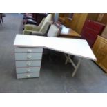 A WHITE MELAMINE SINGLE PEDESTAL DESK WITH ANGLED TOP, FIVE DRAWERS WITH RED EDGE DETAIL