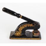 EARLY TWENTIETH CENTURY JAPANNED STEEL GILT EMBELLISHED DESK PUNCH