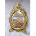 NAPOLEON III BRASS FRAMED WALL MIRROR, the oval, bevel edged plate, within a conforming, moulded