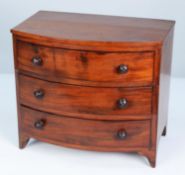 APPRENTICE PIECE, EARLY NINETEENTH CENTURY FIGURED MAHOGANY MINIATURE BOW FRONTED CHEST OF THREE