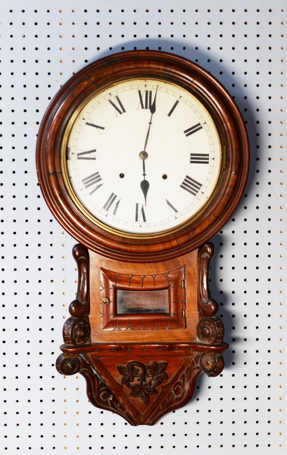 LATE NINETEENTH CENTURY CARVED WALNUT DROP DIAL WALL CLOCK, with 12” enamelled Roman dial and the