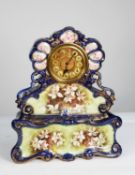 VICTORIAN HAND PAINTED POTTERY MANTLE CLOCK, the 6” Roman brass dial with engine turned centre,