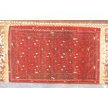 TURKOMAN BOKHARA RUG, crimson with stencilled black pattern with white highlights, multiple border