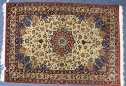 KIRMAN, PERSIAN RUG with shaped circular crimson medallion on an ivory field with scattered formal