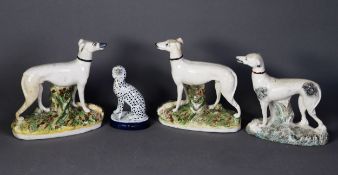 PAIR OF NINETEENTH CENTURY STAFFORDSHIRE FLAT BACK POTTERY MODELS OF WHITE GREYHOUNDS, each modelled