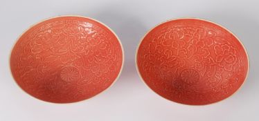 PAIR OF CHINESE PORCELAIN SALMON PINK SHALLOW CIRCULAR BOWLS, embossed in low relief with flowers