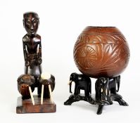 AFRICAN CARVED EBONY FIGURE OF A DRUMMER, modelled standing behind two drums with carved bone