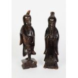 TWO CHINESE BLACK PATINATED CARVED SOFTWOOD FIGURES OF DEITIES, 11 3/4" and 12" high (29.5cm and