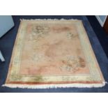 EMBOSSED WASHED CHINESE CARPET, the plain coral pink decoration to the corners with large floral and