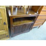 A WOOD BROS. OAK TV CABINET, HAVING AN OPEN SECTION OVER TWO LINEN FOLD PANEL DOORS