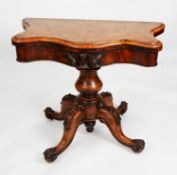 VICTORIAN FIGURED AND CARVED WALNUT PEDESTAL CARD TABLE, the fold-over top of serpentine outline