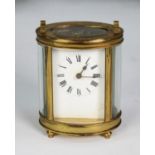 EARLY TWENTIETH CENTURY FRENCH OVAL BRASS PRESENTATION CARRIAGE CLOCK, with top handle, Roman mask