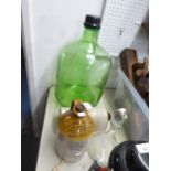 A LARGE GREEN GLASS CARBOY, A STONEWARE ADVERTISING FLAGON, A STONEWARE HOT WATER BOTTLE, AND A