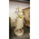 A CONTINENTAL WHITE PARIAN FIGURE OF A WOMAN FLOWER SELLER, ON CIRCULAR BASE, 9 ½” HIGH (HEAD AND