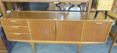A LONG TEAK SIDEBOARD, HAVING DOUBLE CENTRAL CUPBOARDS, FLANKED BY THREE DRAWERS AND A DROP-DOWN
