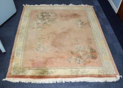 EMBOSSED WASHED CHINESE CARPET, the plain coral pink decoration to the corners with large floral and