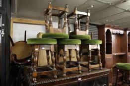 A SUITE OF SIX GREEN VELOUR CIRCULAR TOPPED STOOLS WITH BEECHWOOD BASES