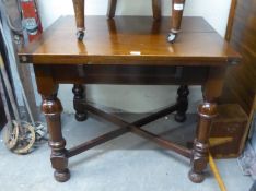 A MAHOGANY DINING TABLE WITH SWIVEL AND FLAP TOP, RAISED ON TURNED SUPPORTS