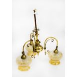 EARLY TWENTIETH CENTURY BRASS THREE LIGHT ELECTROLIER, with scroll arms and amber glass shades