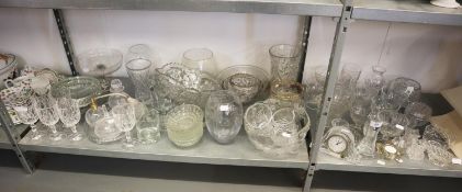 A LARGE QUANTITY OF GLASSWARES TO INCLUDE; A WATERFORD SMALL MANTEL CLOCK, VARIOUS BOWLS, VASES,