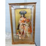 JAPANESE COSTUME DOLL, ELABORATELY DRESSED AS A GEISHA, 17" HIGH (43cm) IN OAK AND GLAZED CASE, A