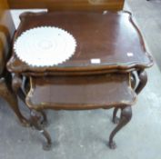 A BURR-WALNUTWOOD QUEEN ANNE STYLE NEST OF THREE COFFEE TABLES, HAVING SHAPED GLASS INSET TOPS,