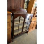 A GEORGE V MAHOGANY TWO DOOR DISPLAY CABINET, RAISED ON CABRIOLE LEGS