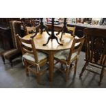 A WAXED PINE CIRCULAR DINING TABLE AND FOUR RUSH-SEATED DINING CHAIRS (5)