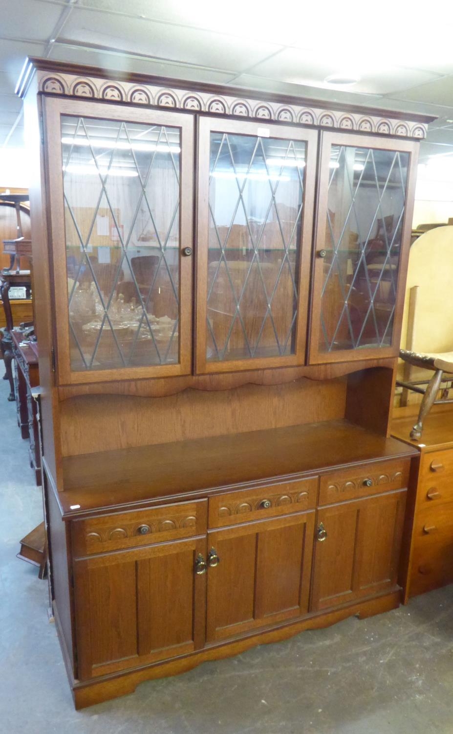 A CARVED OAK LARGE DRESSER WITH 3 LEAD LIGHT GLAZED DOORS ABOVE 2 PANEL DOORS