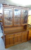 A CARVED OAK LARGE DRESSER WITH 3 LEAD LIGHT GLAZED DOORS ABOVE 2 PANEL DOORS