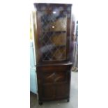 OAK FLOOR STANDING CORNER CABINET, HAVING LEADED GLAZED DOOR TO TOP SECTION AND CUPBOARD DOOR