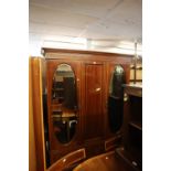 AN EDWARDIAN MAHOGANY INLAID TWO DOOR WARDROBE, EACH DOOR HAVING AN OVAL MIRROR, FLANKING A PANEL